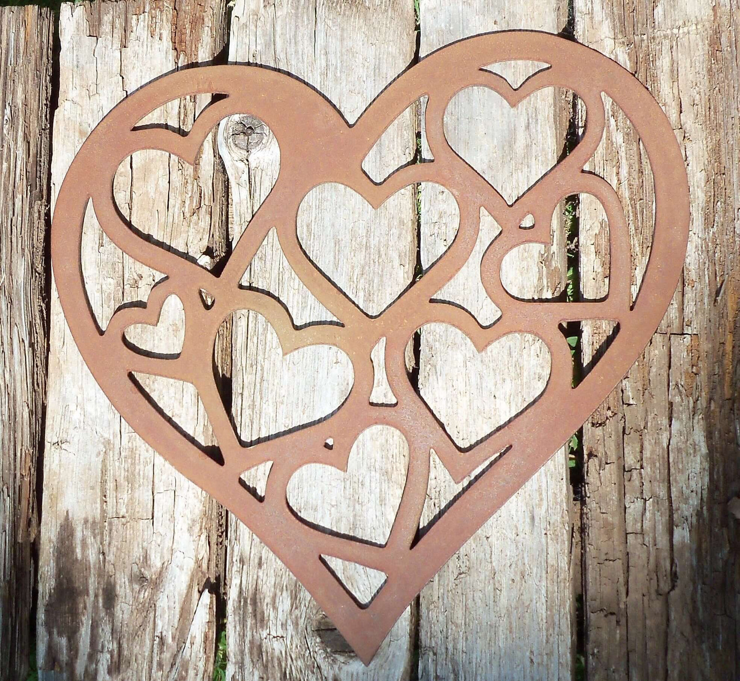 Rusty Metal LOVE HEART of HEARTS Garden Ornament displayed on rustic wooden surface.