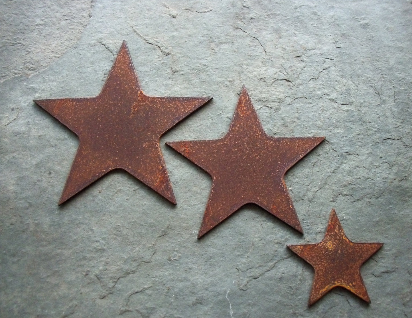 Rustic metal stars set garden decor on a grey stone, 3 piece set with unique patina effect.