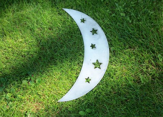 Rustic Metal Garden Ornaments - metal crescent moon garden ornament with star cutouts on green grass.