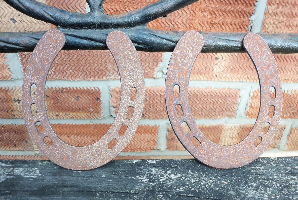 Rusty Steel PAIR OF HORSESHOES Garden Ornaments - Rustic metal outdoor decorations displayed on a wooden surface.