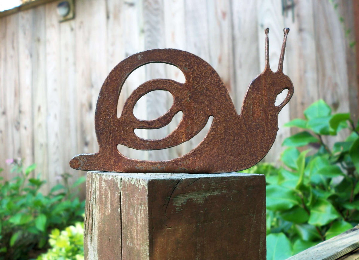 Rusty Steel Snail Garden Ornament on a wooden post, adding rustic charm to outdoor decor.