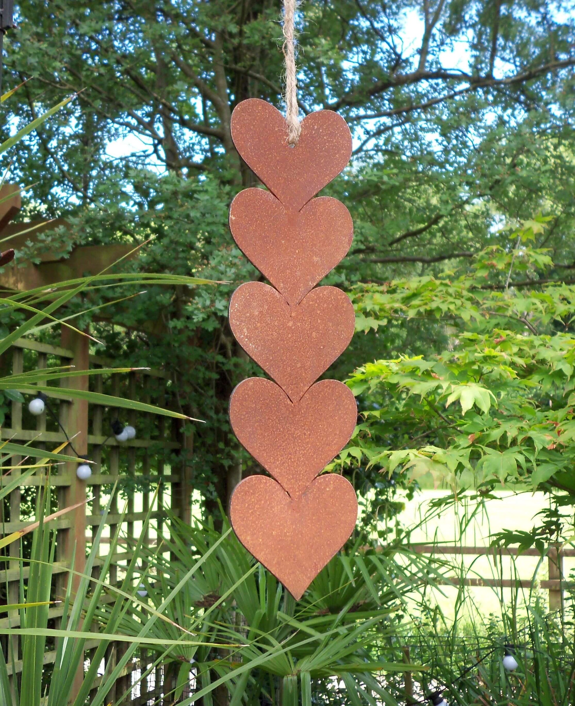 Rusty metal hanging hearts garden ornament featuring five joined hearts with jute string for rustic garden decor.