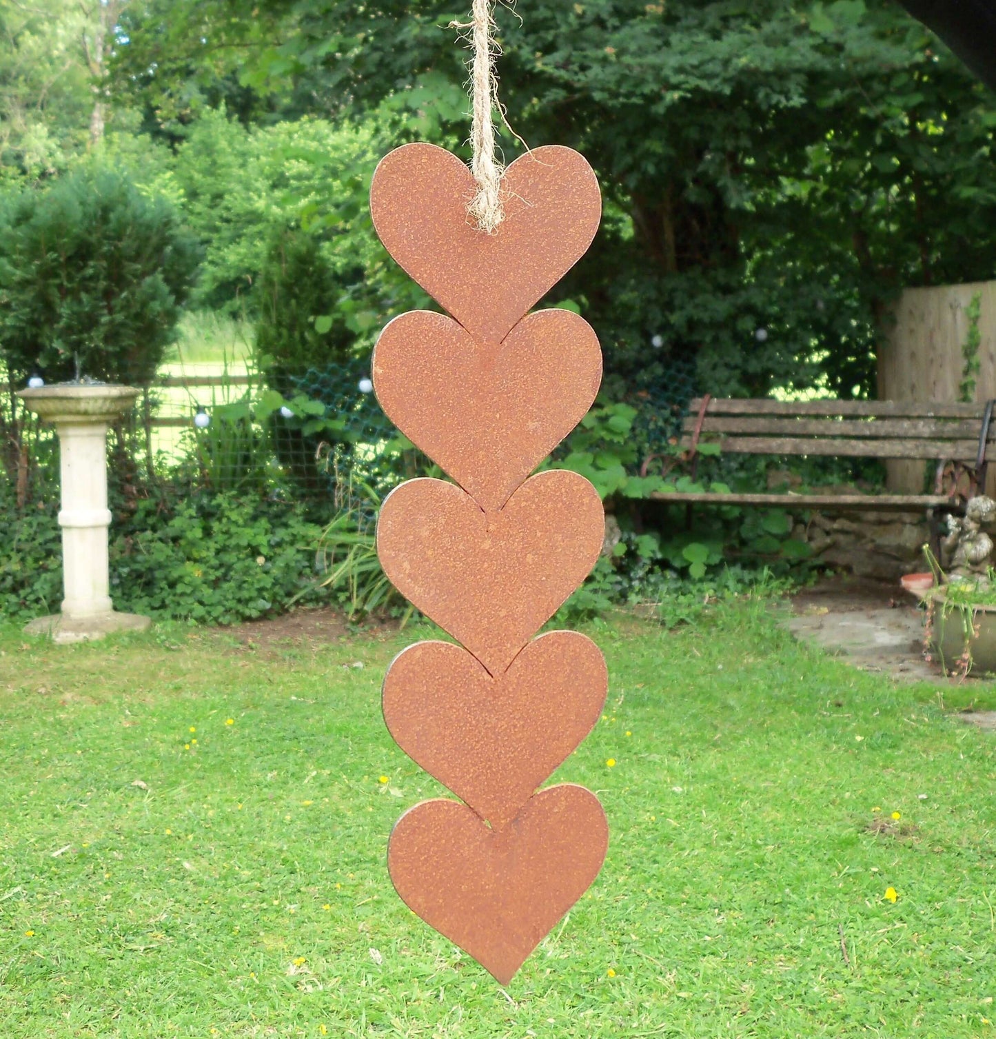 Rusty metal hanging hearts garden ornament featuring five hearts with jute string for rustic garden decor.
