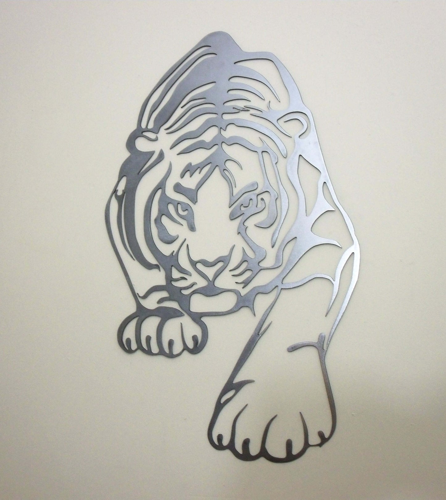 Metal tiger wall art mounted on a beige wall in a modern living space