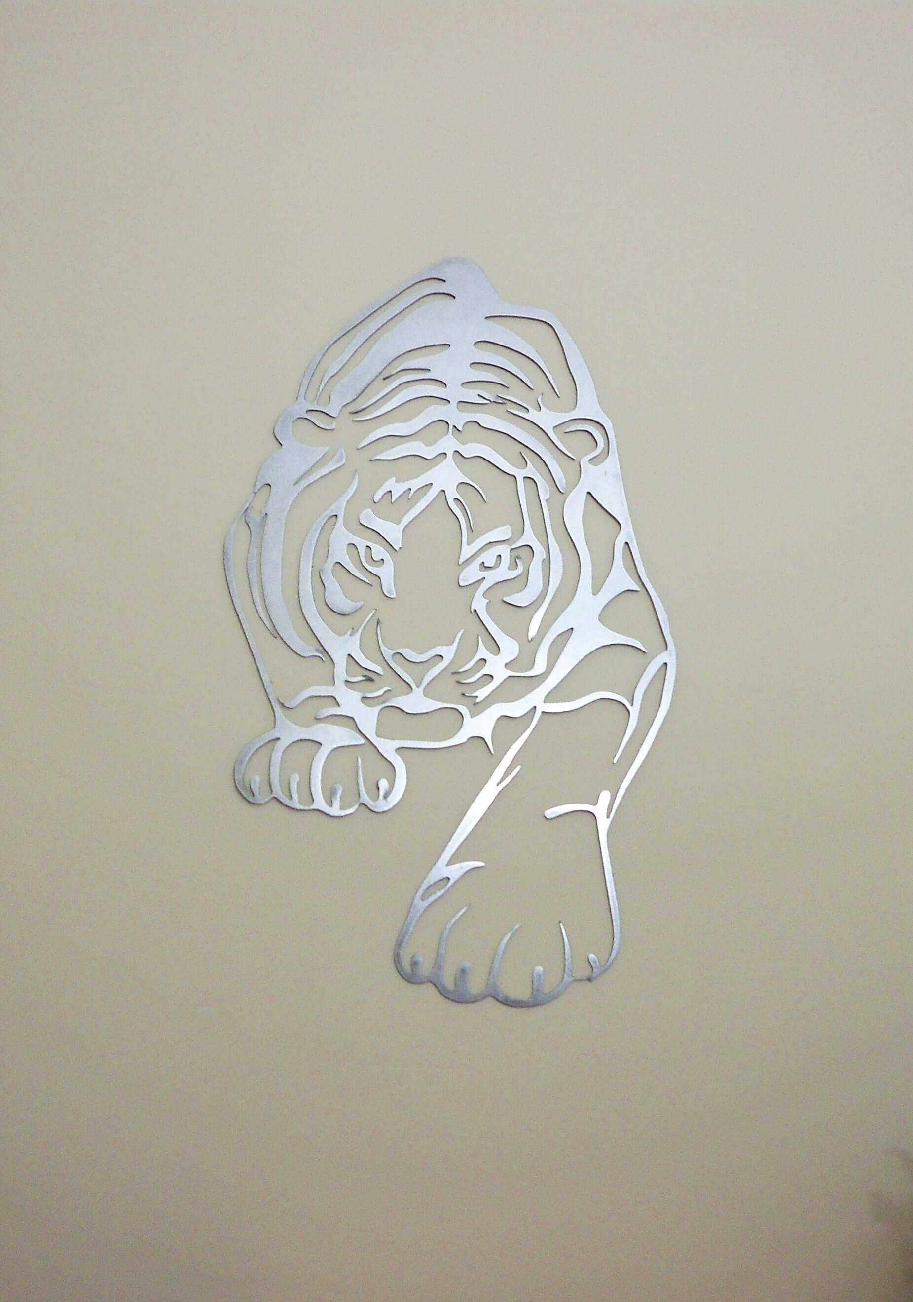 Stunning metal tiger wall art hanging on warm beige background