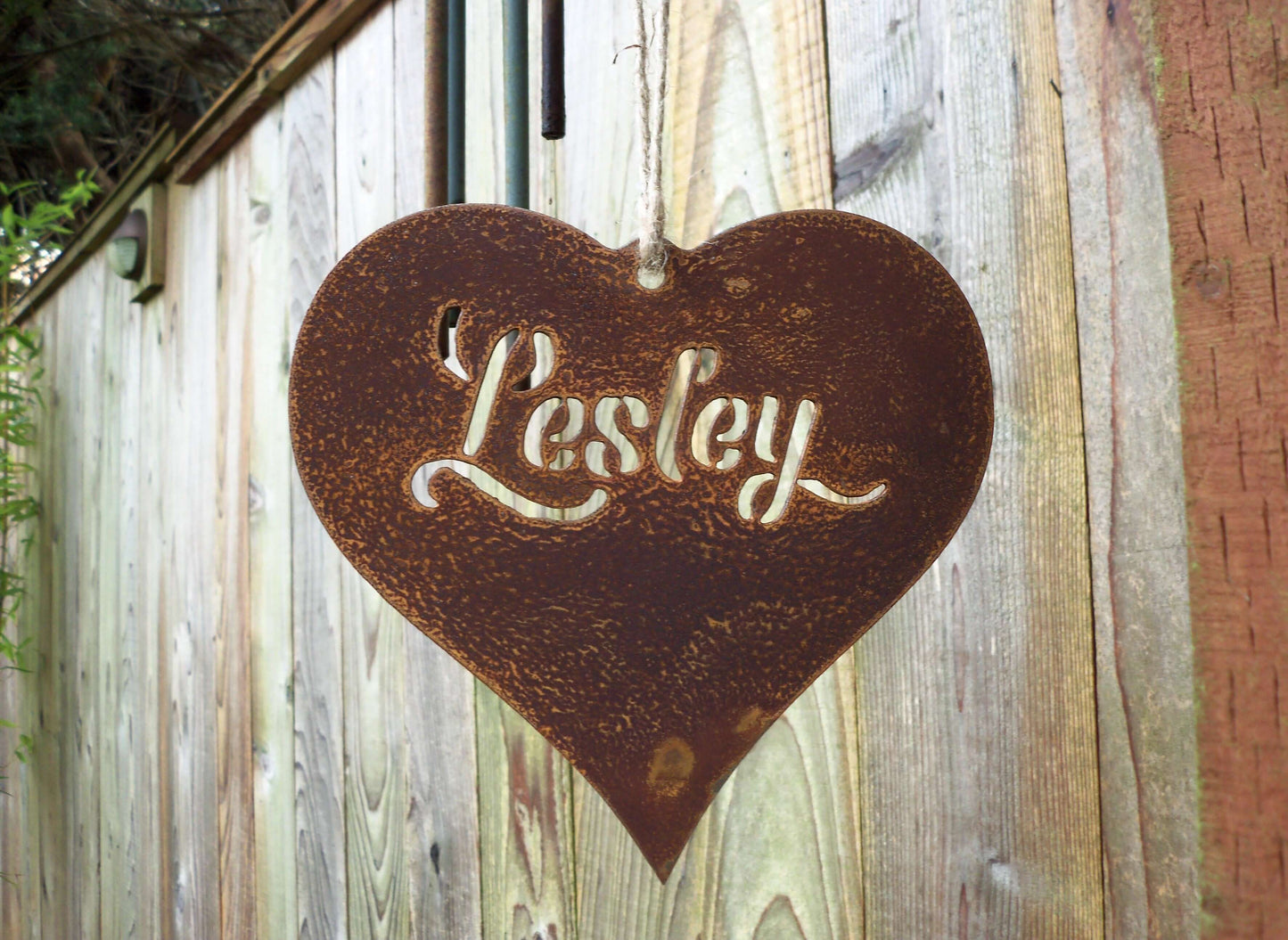 Personalised rusty metal hanging heart ornament hanging from a garden hook