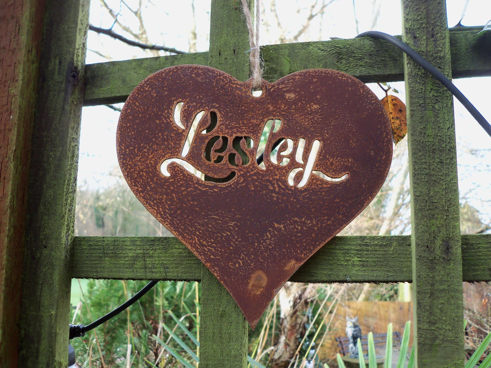 Personalised rusty metal hanging heart ornament plaque displayed on pergola