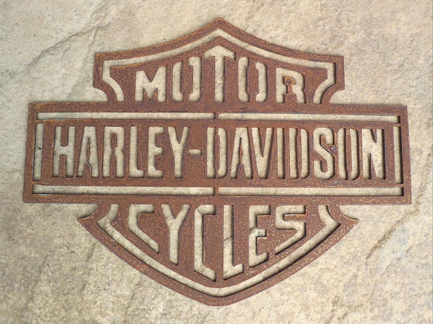 Rustic Metal Harley Davidson Motorcycle Badge Sign on a textured stone background