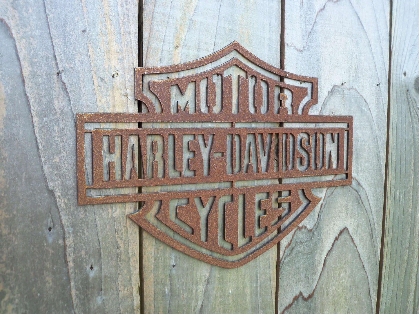 Rustic Metal Harley Davidson Motorcycle Badge Sign on a grey wooden background