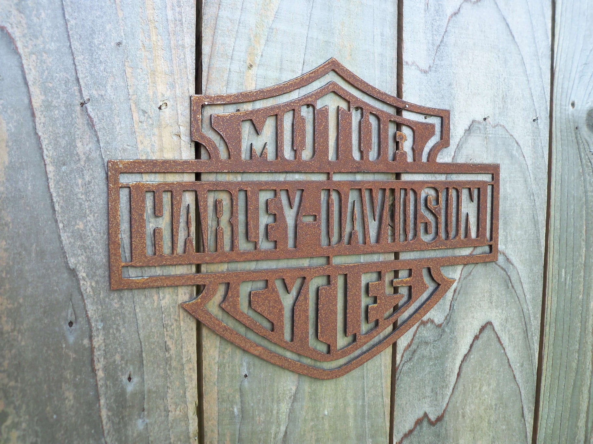 Rustic Metal Harley Davidson Motorcycle Badge Sign on a grey wooden background