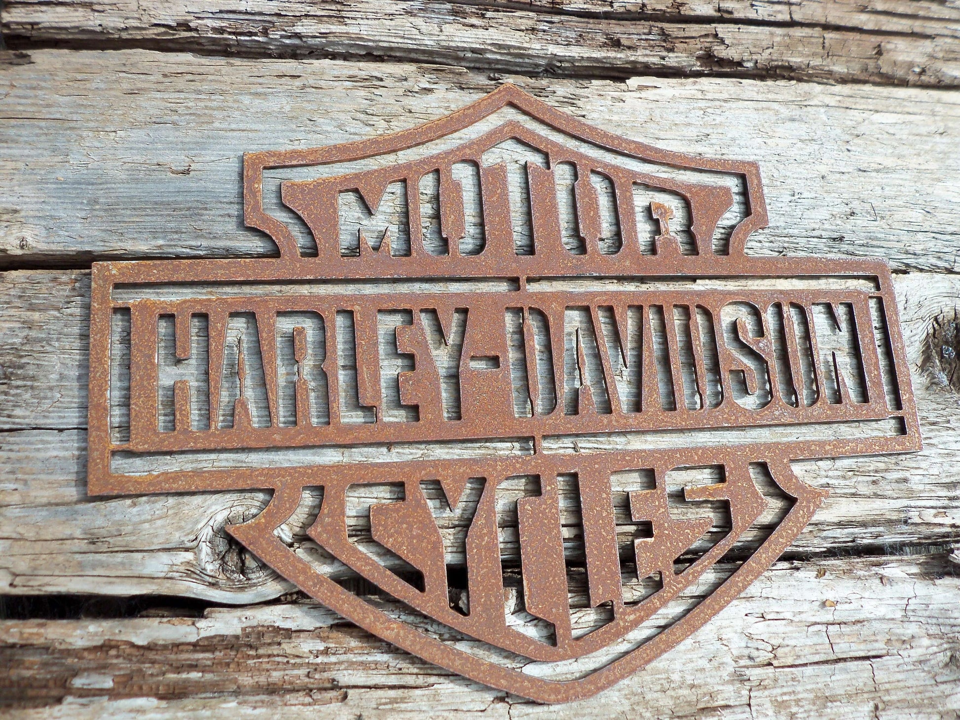 Rustic Metal Harley Davidson Motorcycle Badge Sign on a old wooden background