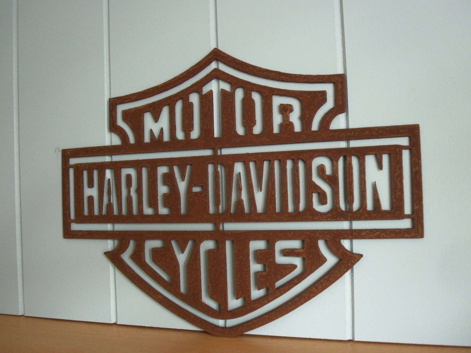 Rustic Metal Harley Davidson Motorcycle Badge Sign on a grey wooden panel background