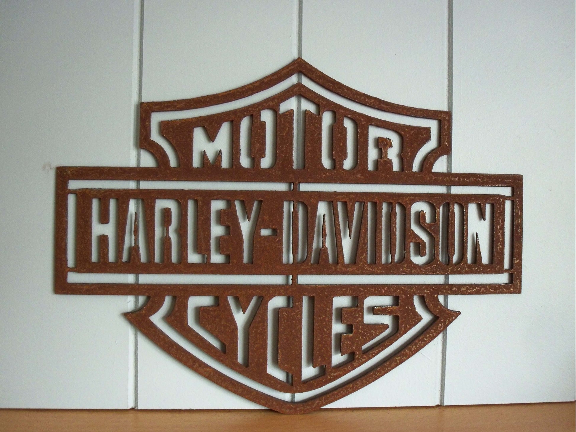 Rustic Metal Harley Davidson Motorcycle Badge Sign on a tiled wall