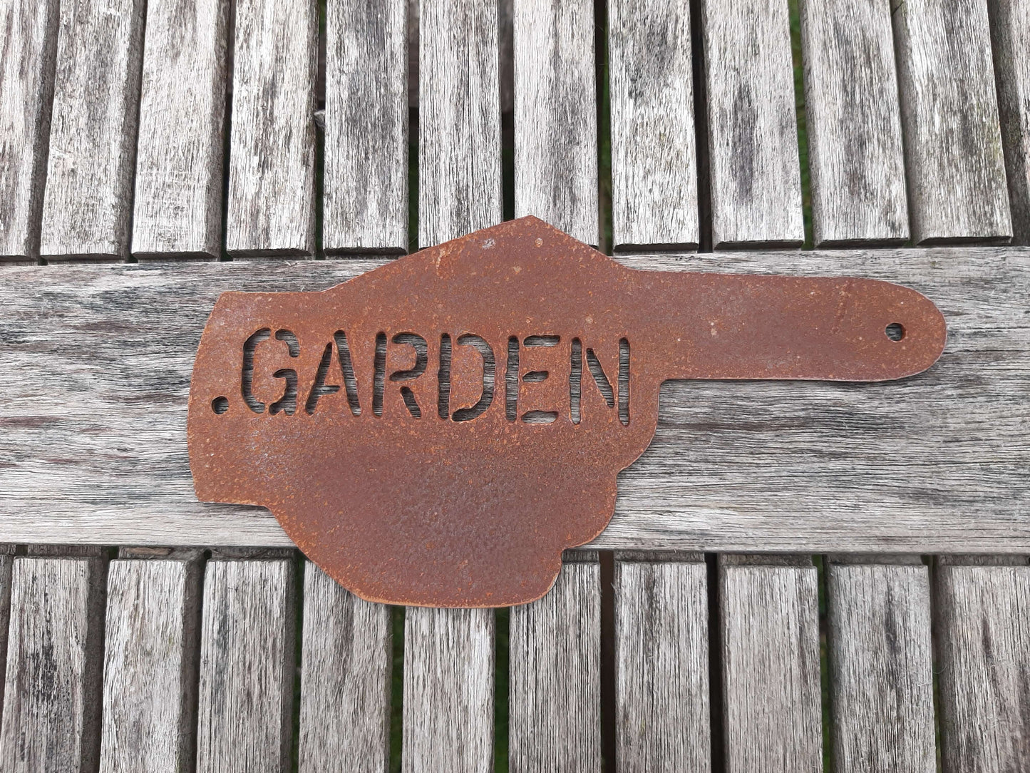 Rusty Metal Hand Pointer Arrow Garden Sign Ornament showing 'GARDEN' on a wooden surface, rustic garden decor.