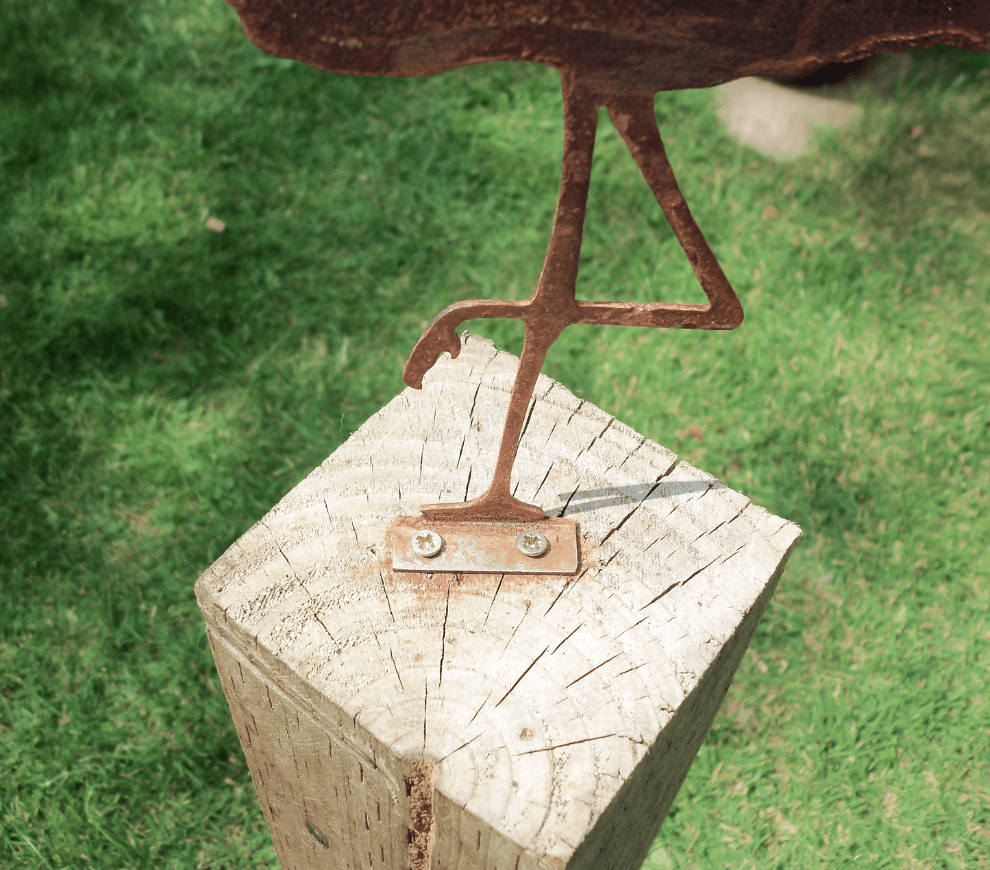 Rusty Metal Flamingo garden ornament mounted on a wooden post with visible screw holes.