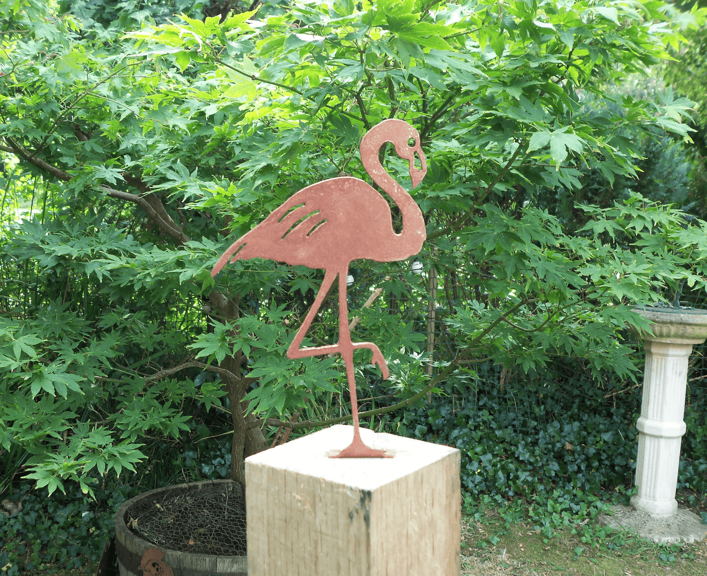 Rusty Metal Flamingo garden ornament displayed in a garden, made from thick steel with a rustic design.