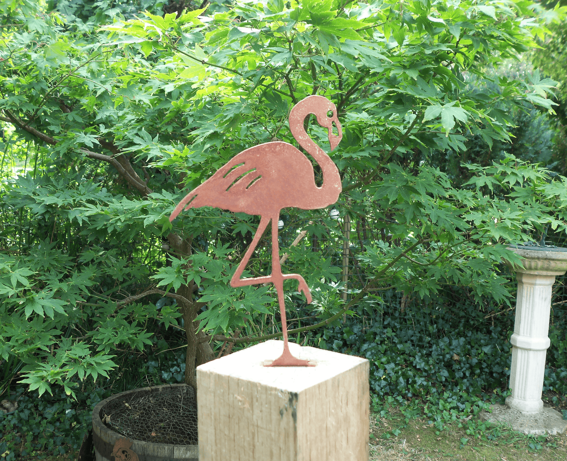 Rusty Metal Flamingo garden ornament displayed in a garden, made from thick steel with a rustic design.