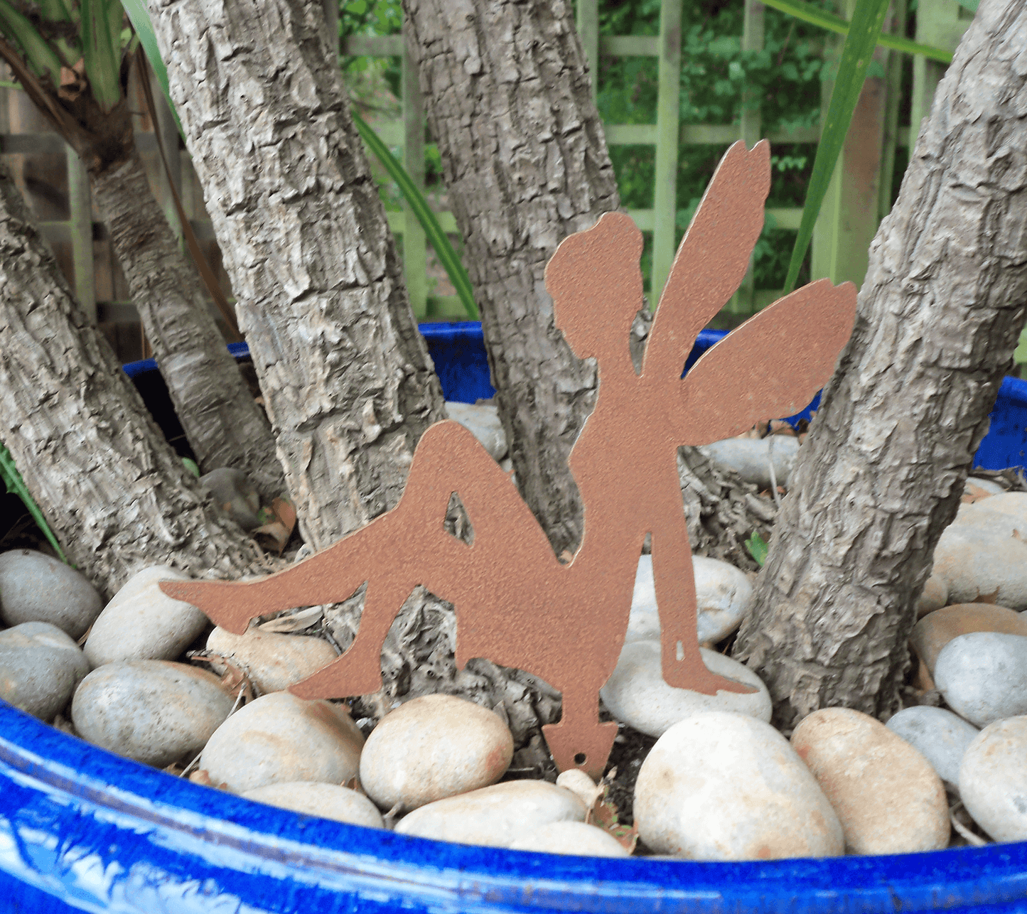 Rusty Steel Fairy garden ornament with pot spike in a blue planter with pebbles.