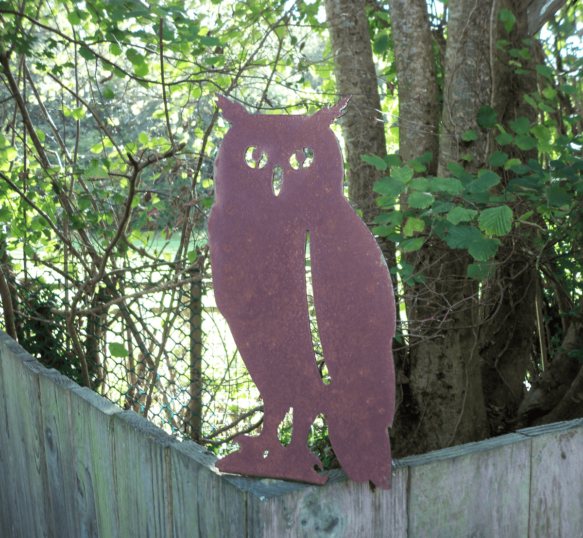 Rustic Steel OWL Garden Ornament standing on a fence, showcasing its unique rusted finish and rustic charm.