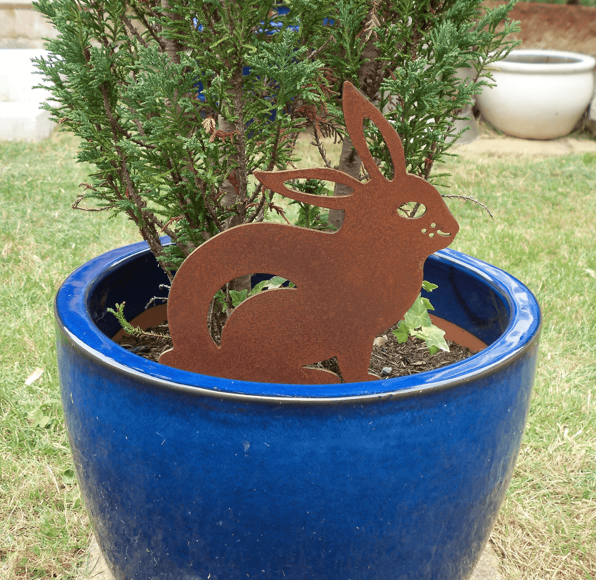 Rusted Steel RABBIT Garden Ornament nestled in a blue pot, showcasing rustic charm and unique patina.