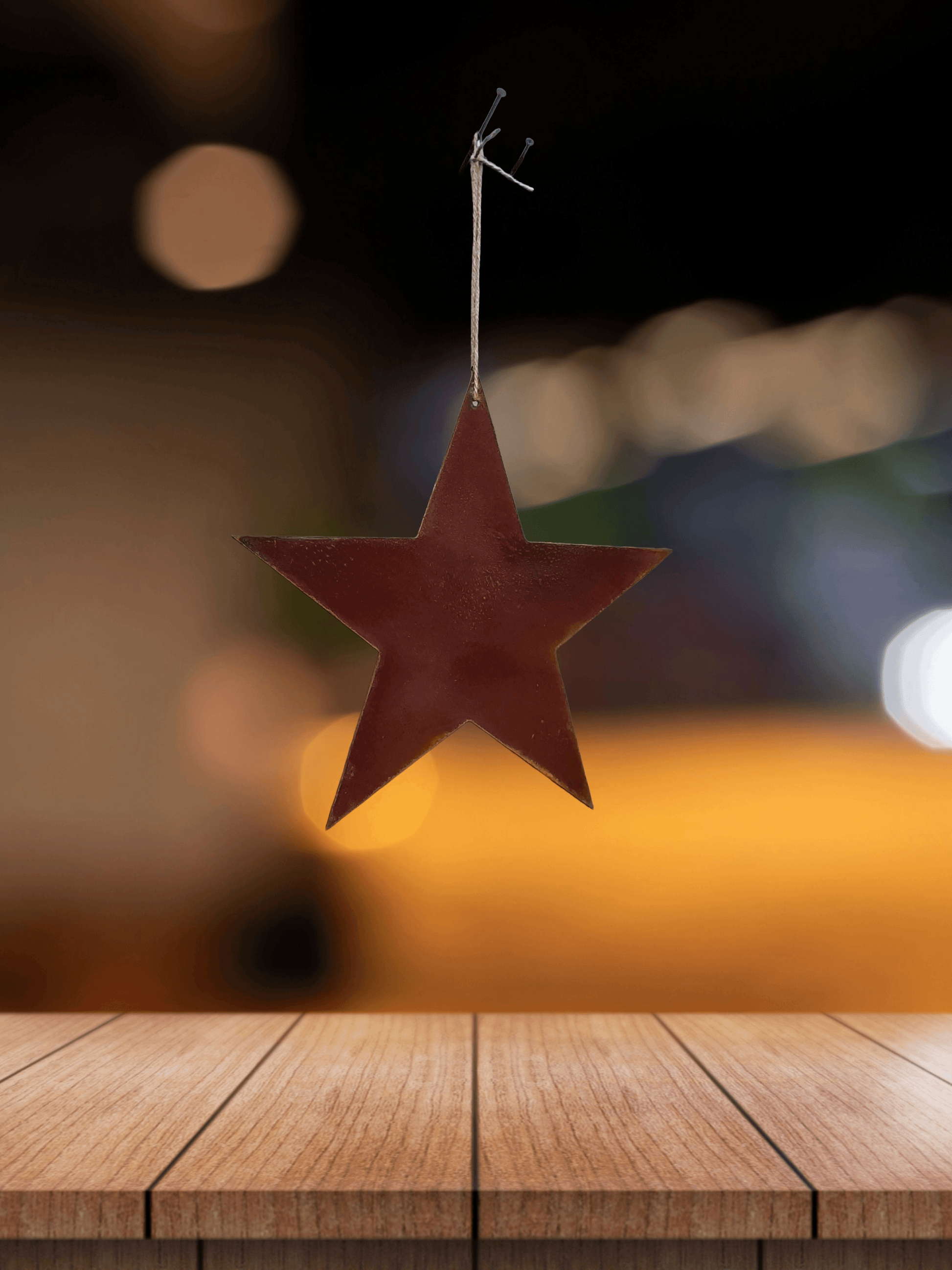 Rusty Metal STAR Garden Ornament hanging above a wooden surface with a blurred background
