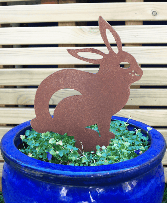 Rusted Steel RABBIT Garden Ornament placed in a blue pot with greenery, showcasing rustic metal decoration.