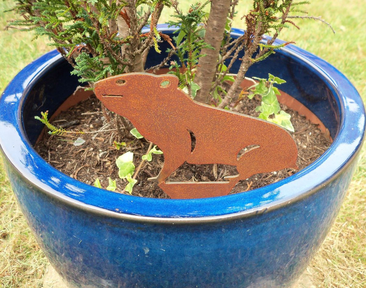 Rusty Steel HAMSTER Garden Ornament displayed in a blue pot with a plant, adding rustic charm to the garden.
