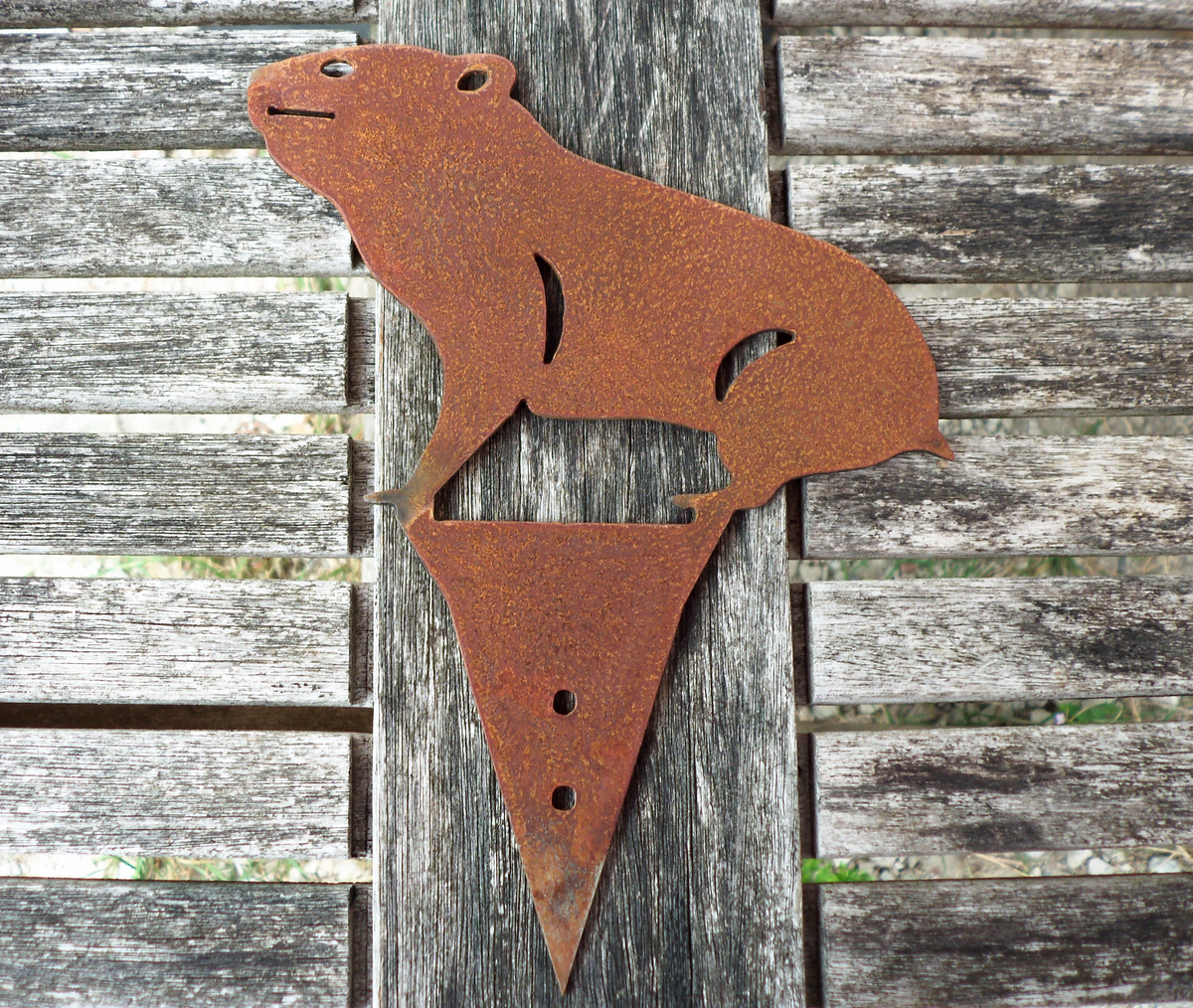 Rusty Steel HAMSTER Garden Ornament on a wooden surface for rustic garden decoration, fence post topper