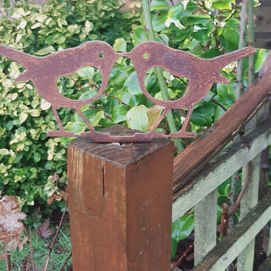 Rusty Metal KISSING ROBINS Birds Garden Ornament on a wooden fence post as an Outdoor Robin Decoration.