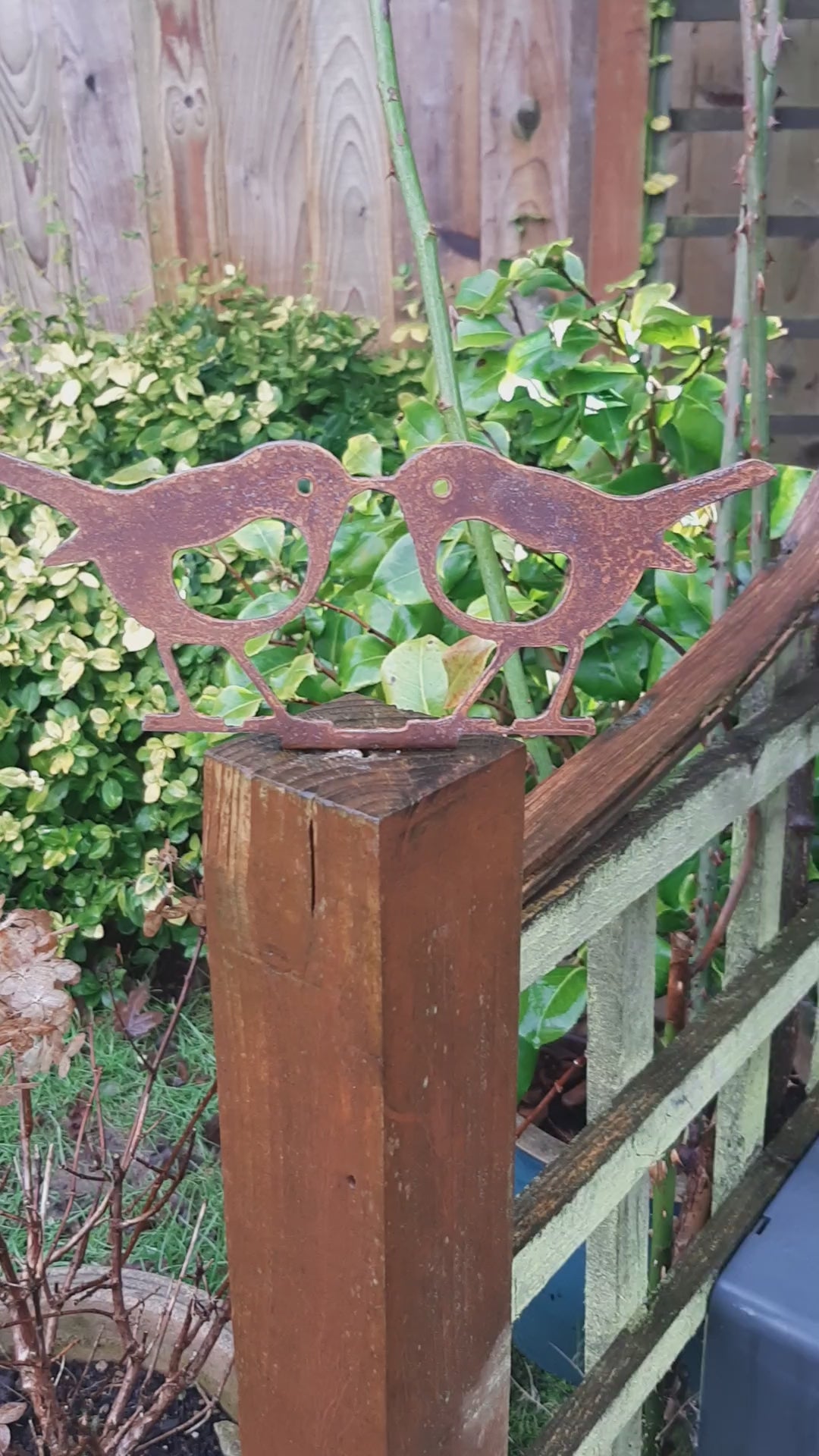 Rusty Metal KISSING ROBINS Birds Garden Ornament on a wooden fence post as an Outdoor Robin Decoration.